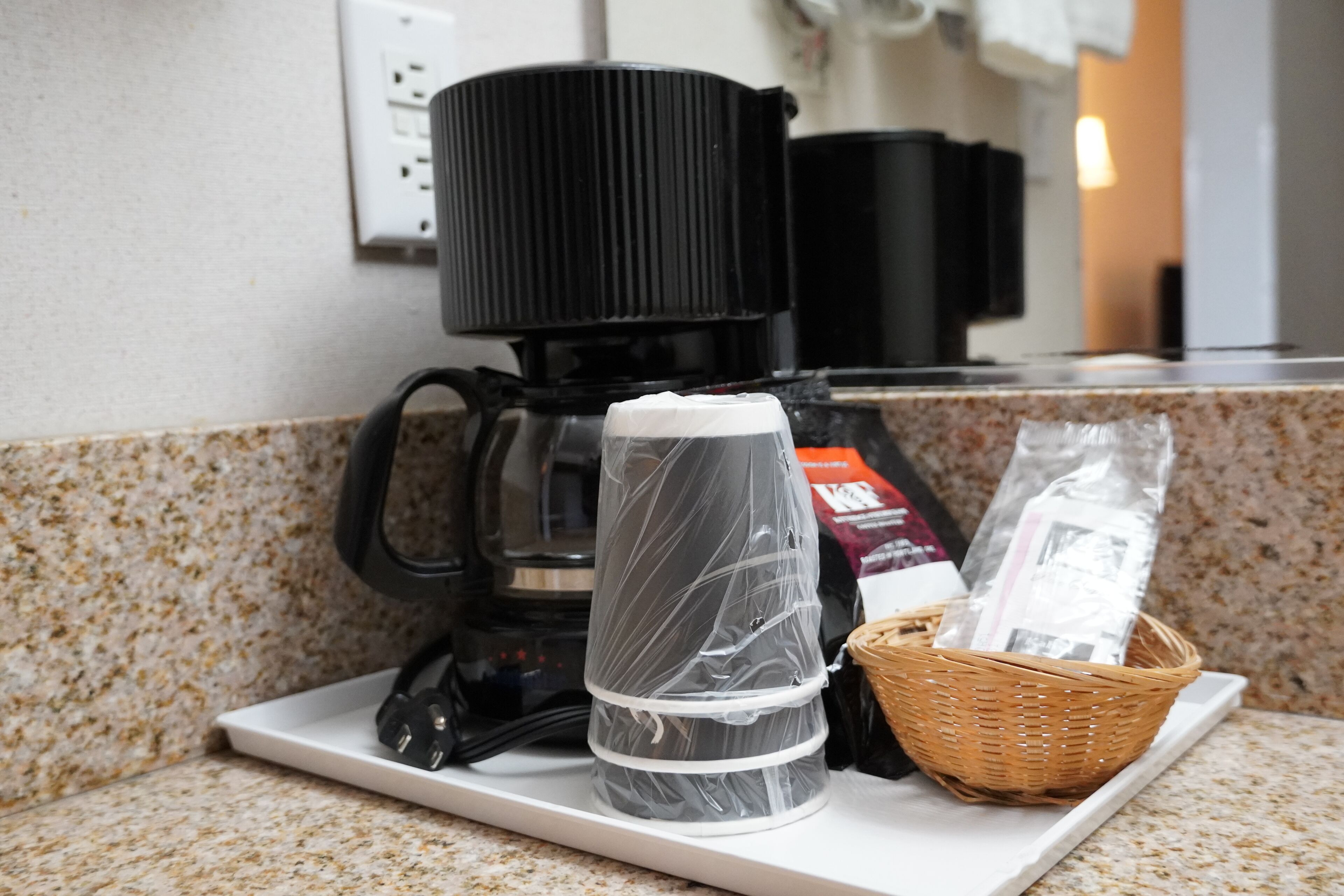 Un comptoir de cuisine avec une machine à café, un panier et un objet emballé.