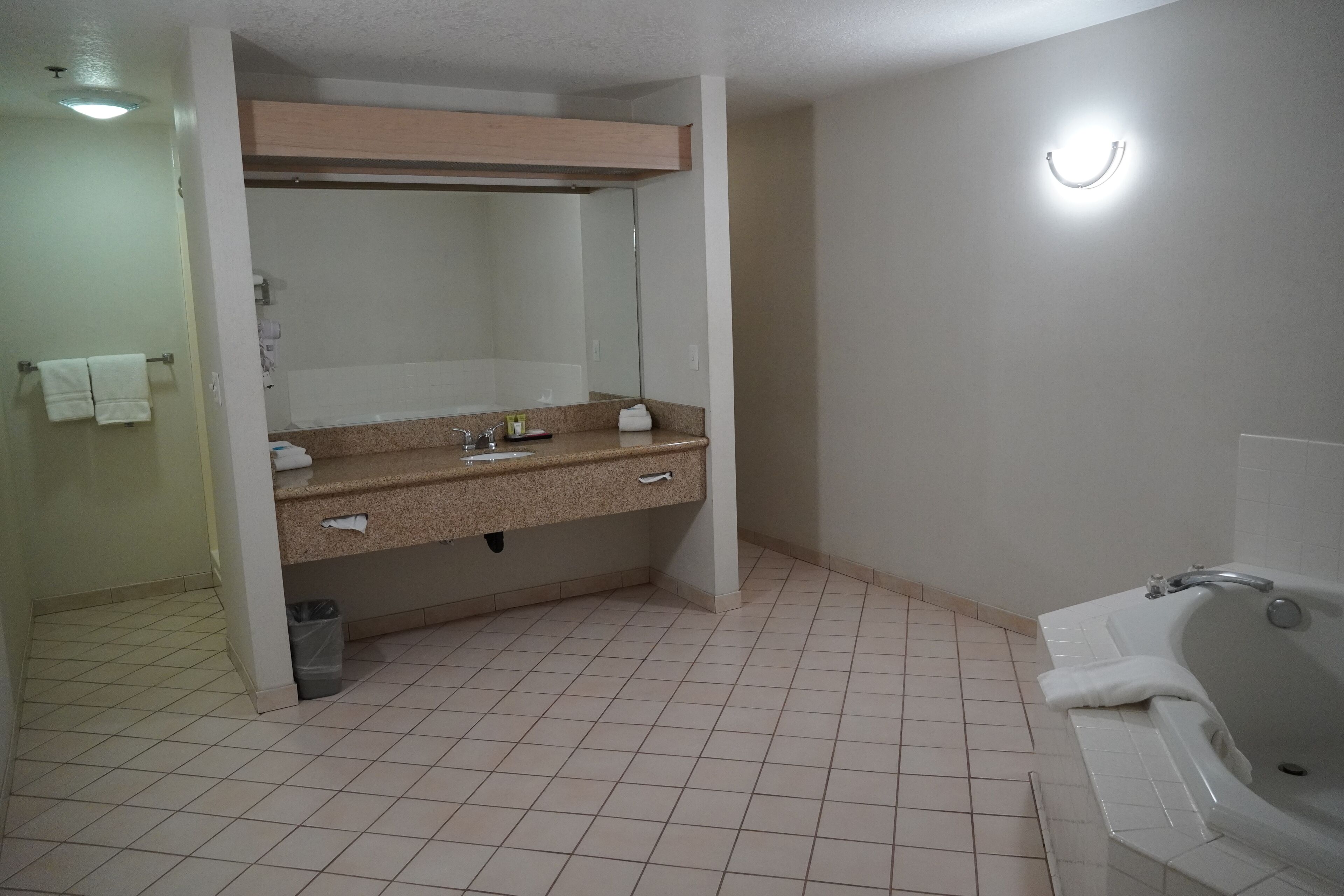 A bathroom with a sink, mirror, and bathtub.
