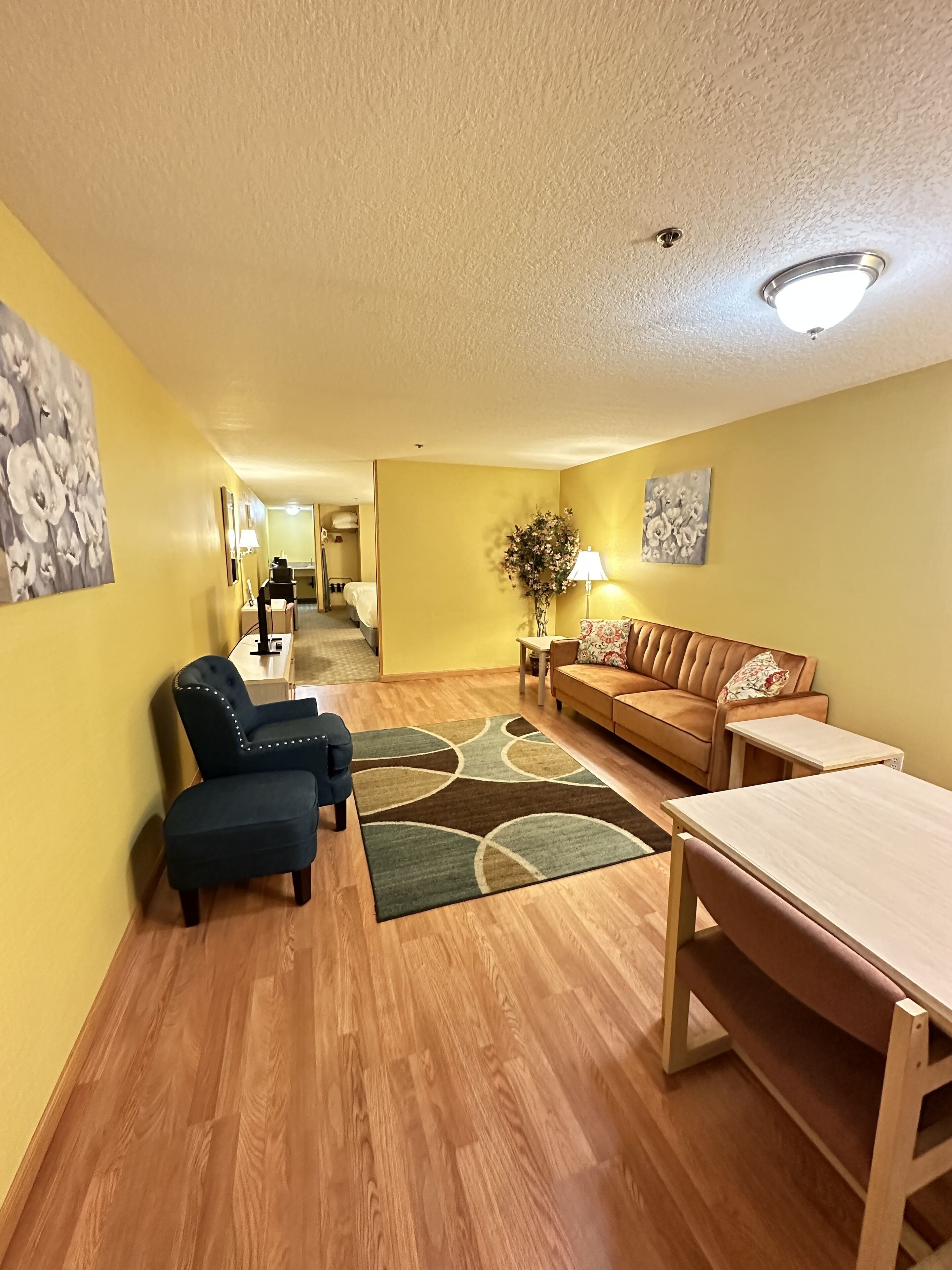 Una sala de estar con sofá, sillones, una mesa de centro y un tapete.