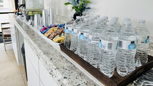 A water dispenser and snacks on a counter in a hotel lobby.
