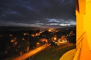 A nighttime view of a town with illuminated buildings and a prominent structure in the distance.
