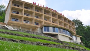 A multi-story hotel with balconies and a curved section. - Hillside Inn (Madison)