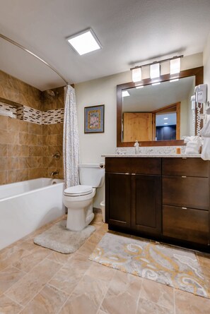 Un baño con bañera, inodoro y tocador.