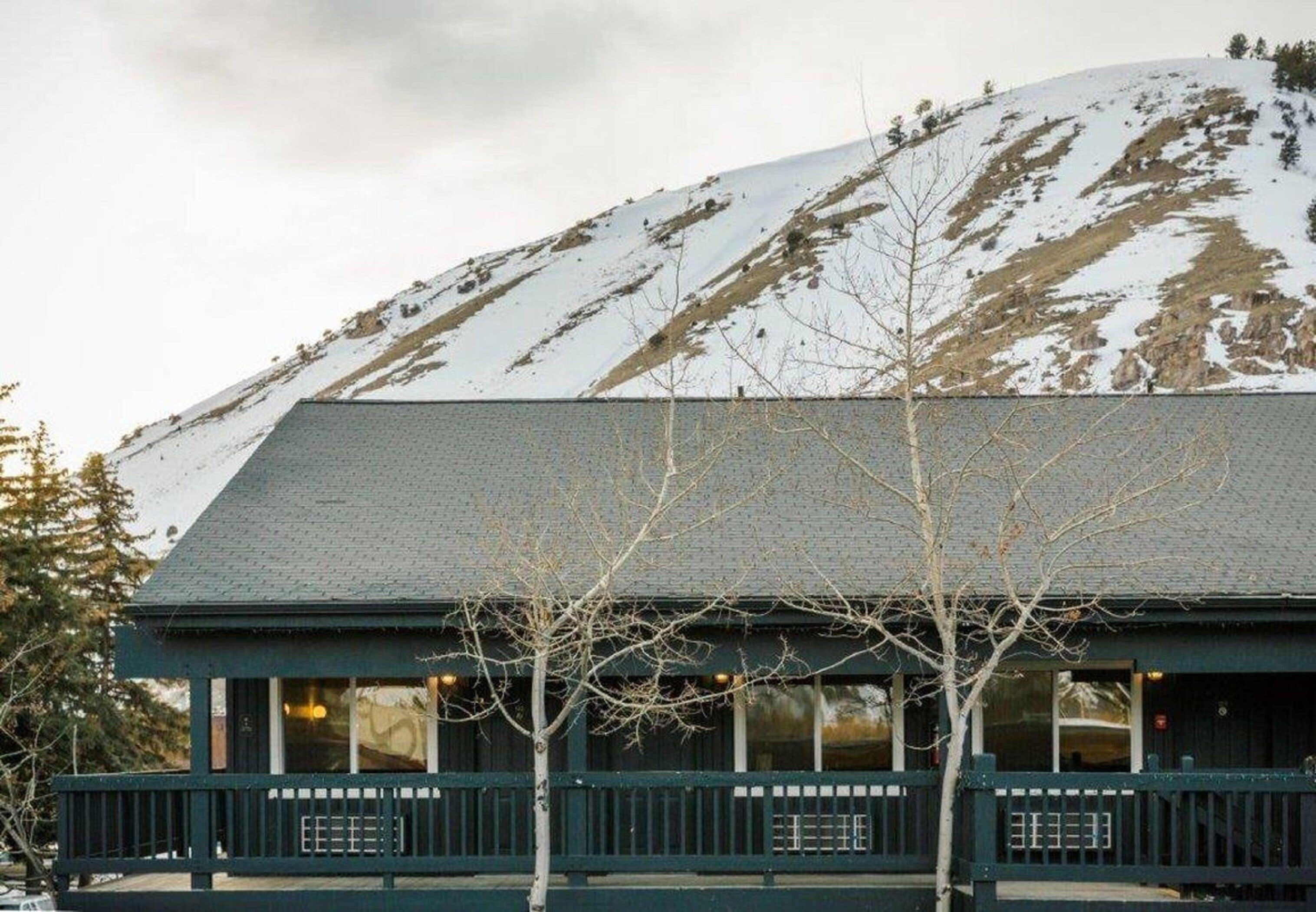A building with a dark roof and a balcony with railings.