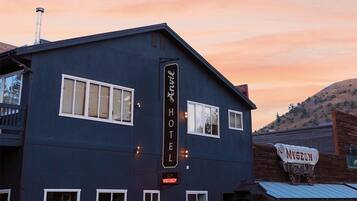 A two-story building with a sign reading 'Anvil Hotel' and a smaller sign for a museum.