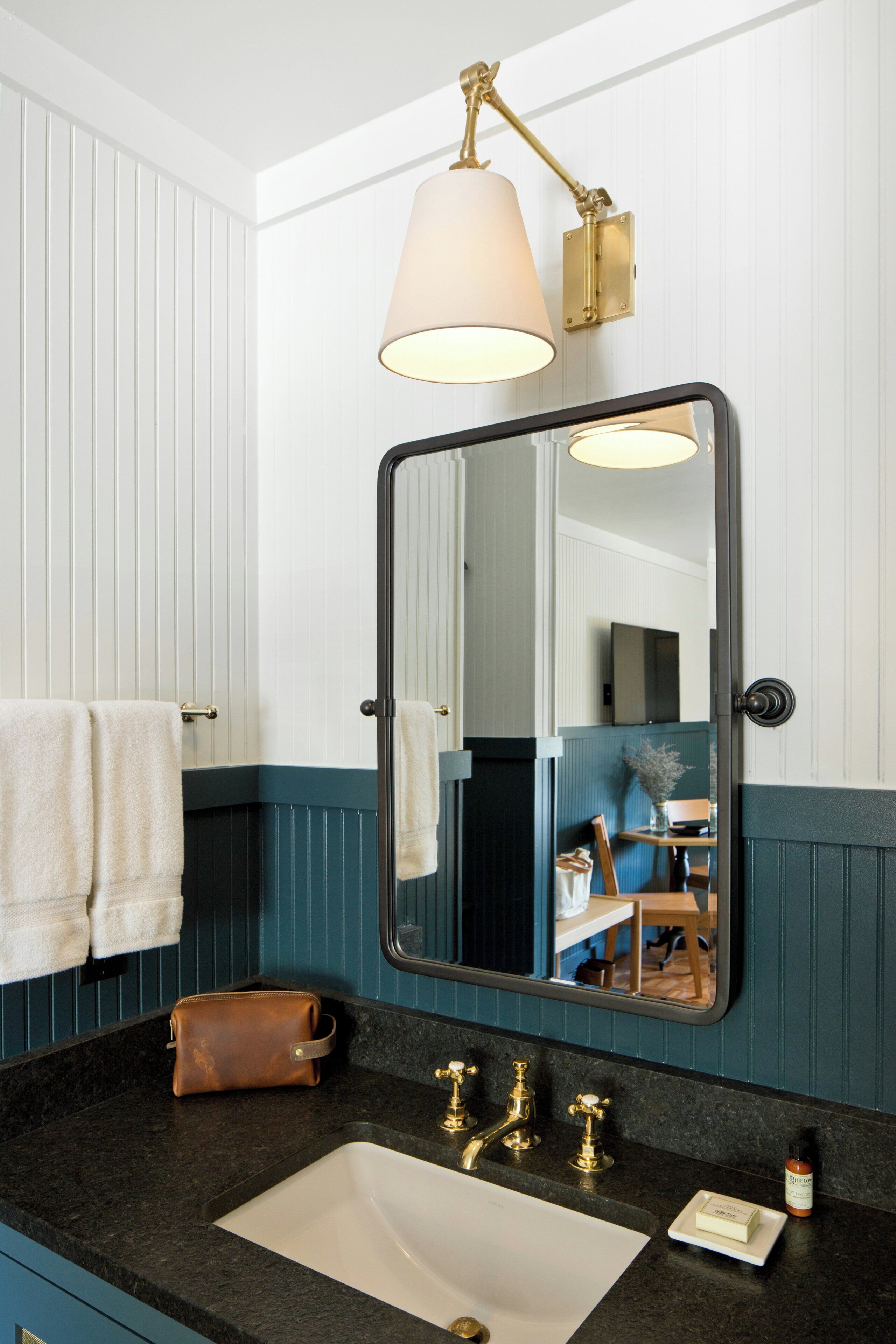 A bathroom with a white sink, a mirror, and a towel rack.