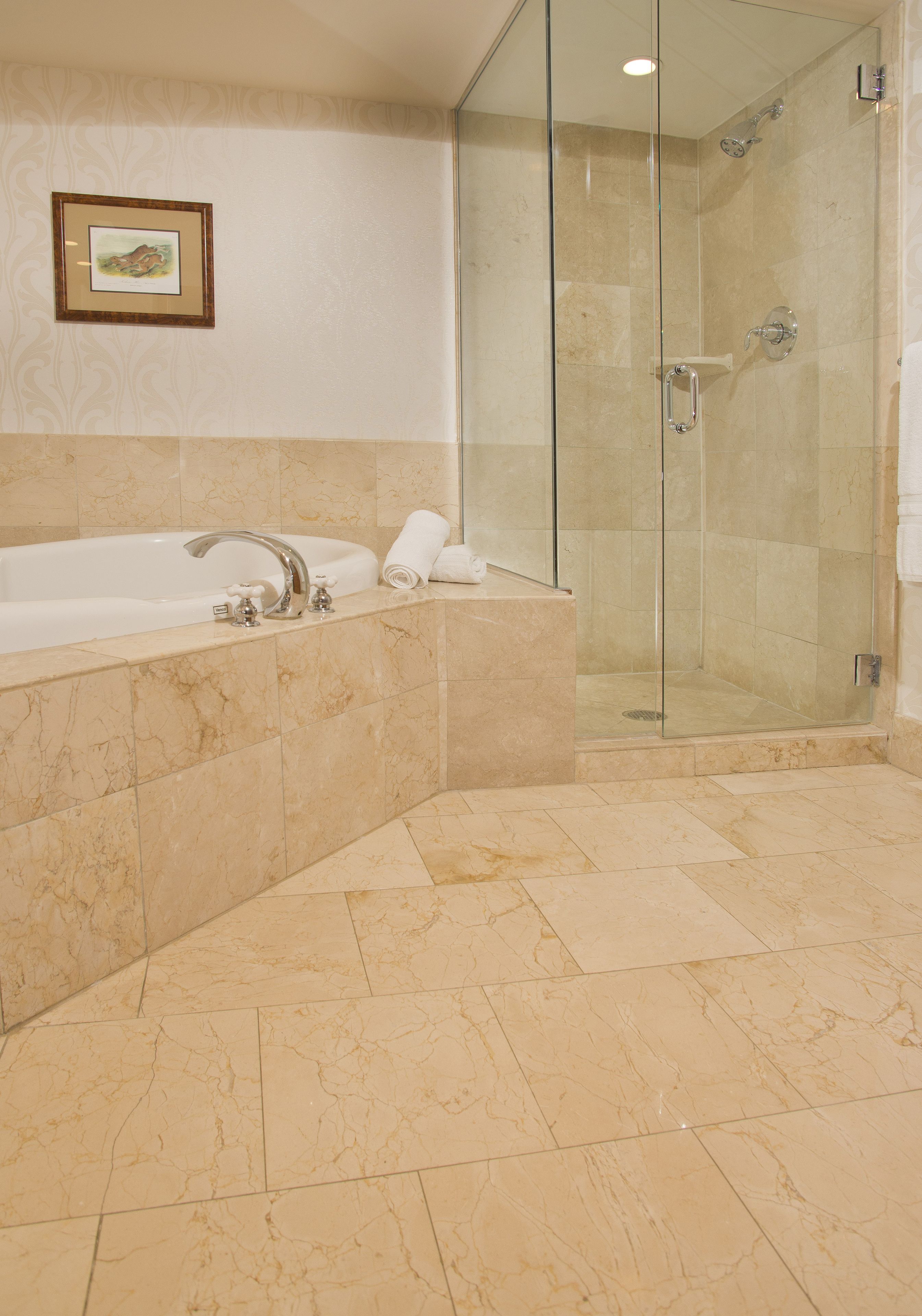 A bathroom with a glass-enclosed shower, a bathtub, and a toilet.