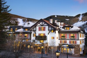 A large, multi-story hotel with a traditional architectural style, featuring balconies with railings and windows with shutters. - Austria Haus (Vail)