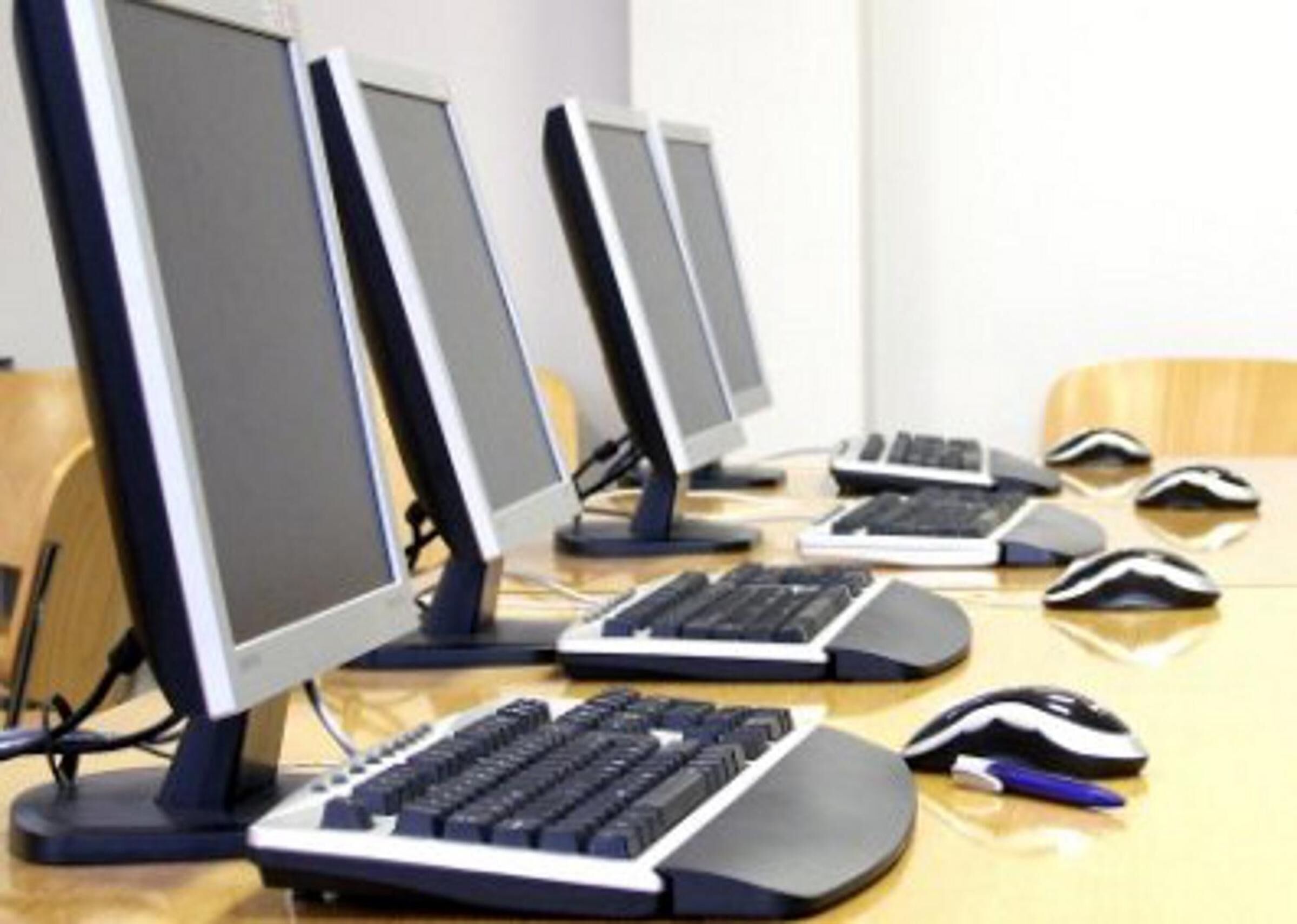 A computer lab with multiple desktop computers, keyboards, and mice.