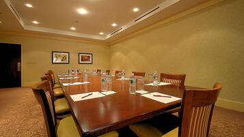 A conference room with a long table, chairs, water bottles, and name cards.