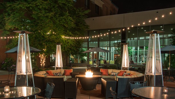 An outdoor patio area with seating, tables, and decorative lights.
