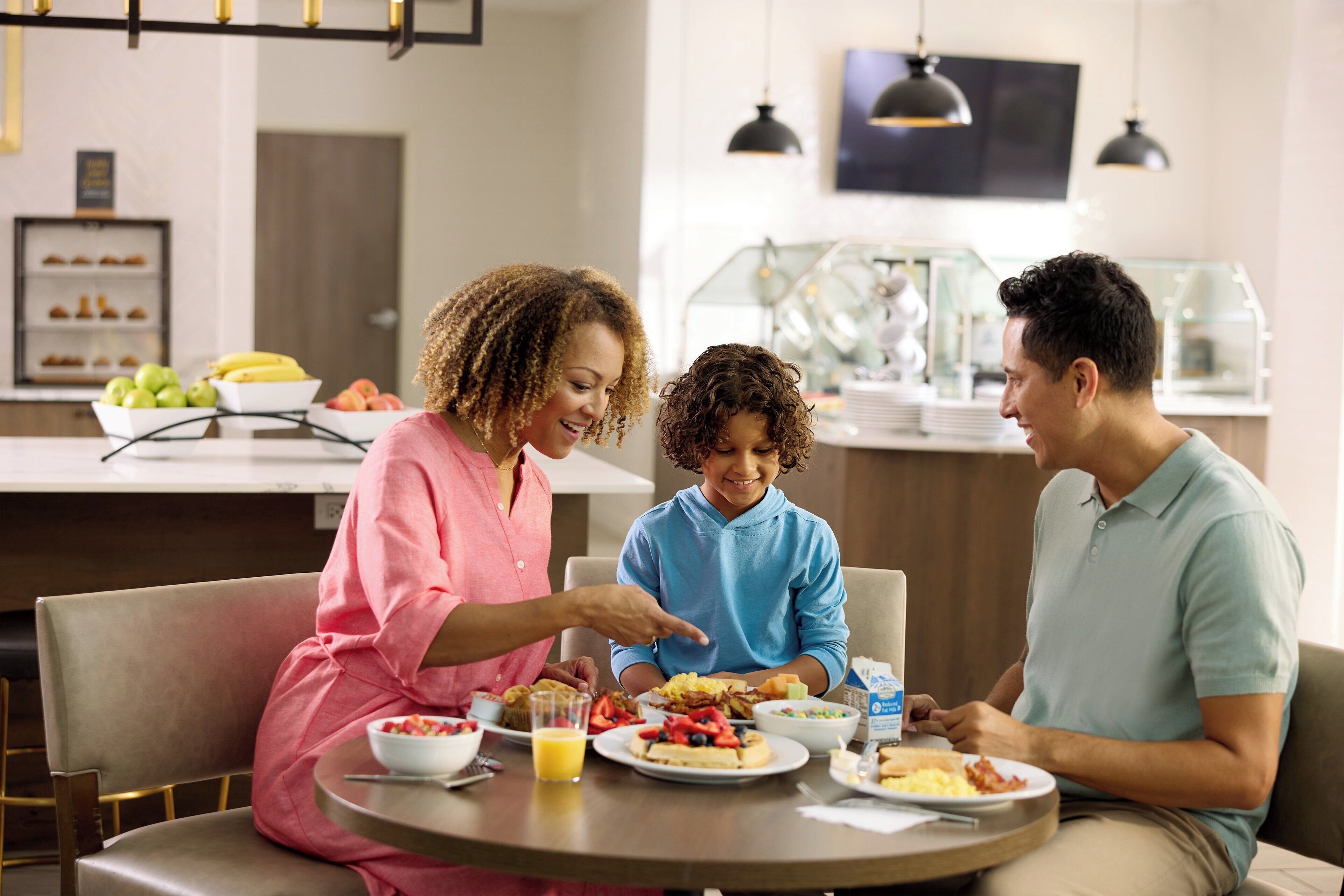 A family dining at a table with breakfast items.