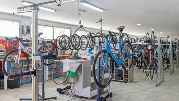 Una tienda de reparación de bicicletas con varias bicicletas y puestos de trabajo.