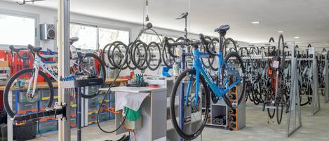 Una tienda de reparación de bicicletas con varias bicicletas y puestos de trabajo.