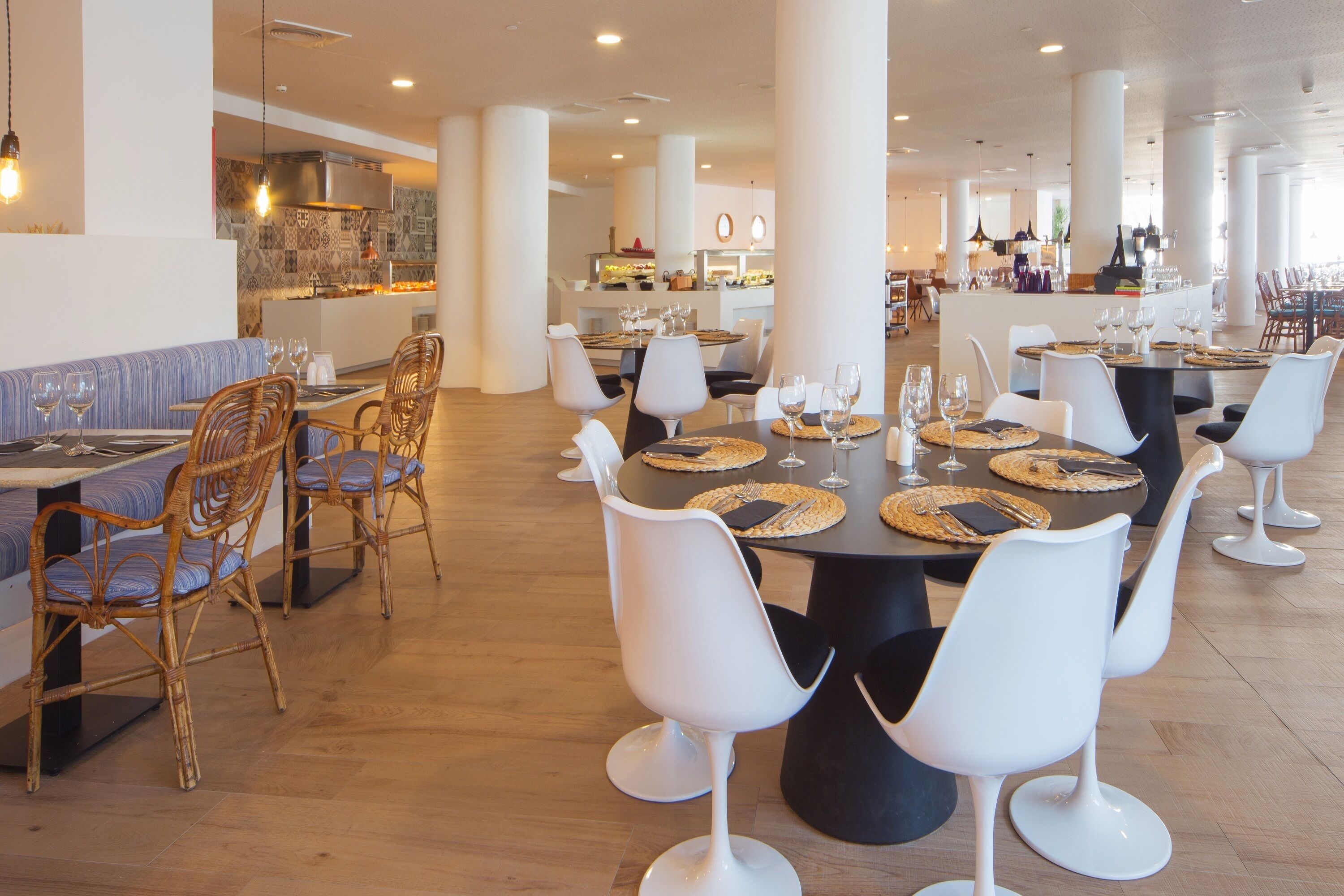 A spacious dining area with high ceilings, modern furniture, and a central island with a bar.