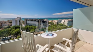 A balcony with white chairs and a small table, overlooking a cityscape and the sea. - Grupotel Taurus Park (Palma de Mallorca)