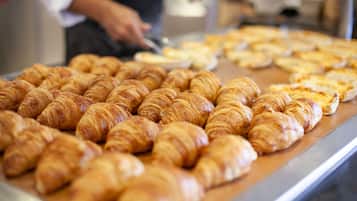 Mostrador de panadería con cruasanes y pizzas.