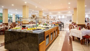 A buffet area with a marble counter, various food items, and wooden chairs. - Grupotel Taurus Park (Palma de Mallorca)