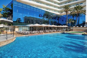 A hotel with a large reflective glass facade, a swimming pool with lounge chairs, and palm trees. - Grupotel Taurus Park (Palma de Mallorca)