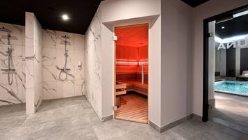 A modern bathroom with a sauna, marble walls, and a visible pool area.