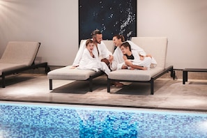 Una piscina techada, sillones reclinables de piscina