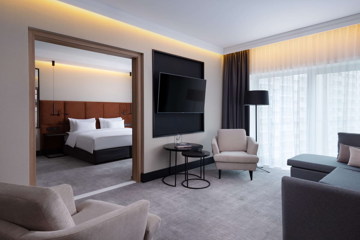Una habitación de hotel con cama, televisión, escritorio y zona de estar.