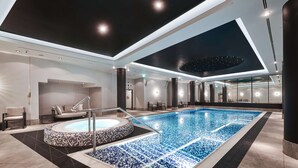 A modern indoor swimming pool with a hot tub, seating area, and a ceiling with a starry design. - Radisson Collection Hotel, Warsaw (Warsaw)