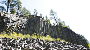 A rocky terrain with a steep cliff and sparse vegetation.