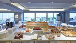 A modern hotel dining area with a buffet of baked goods, pastries, and desserts. - Hotel Plaza Venice (Mestre)