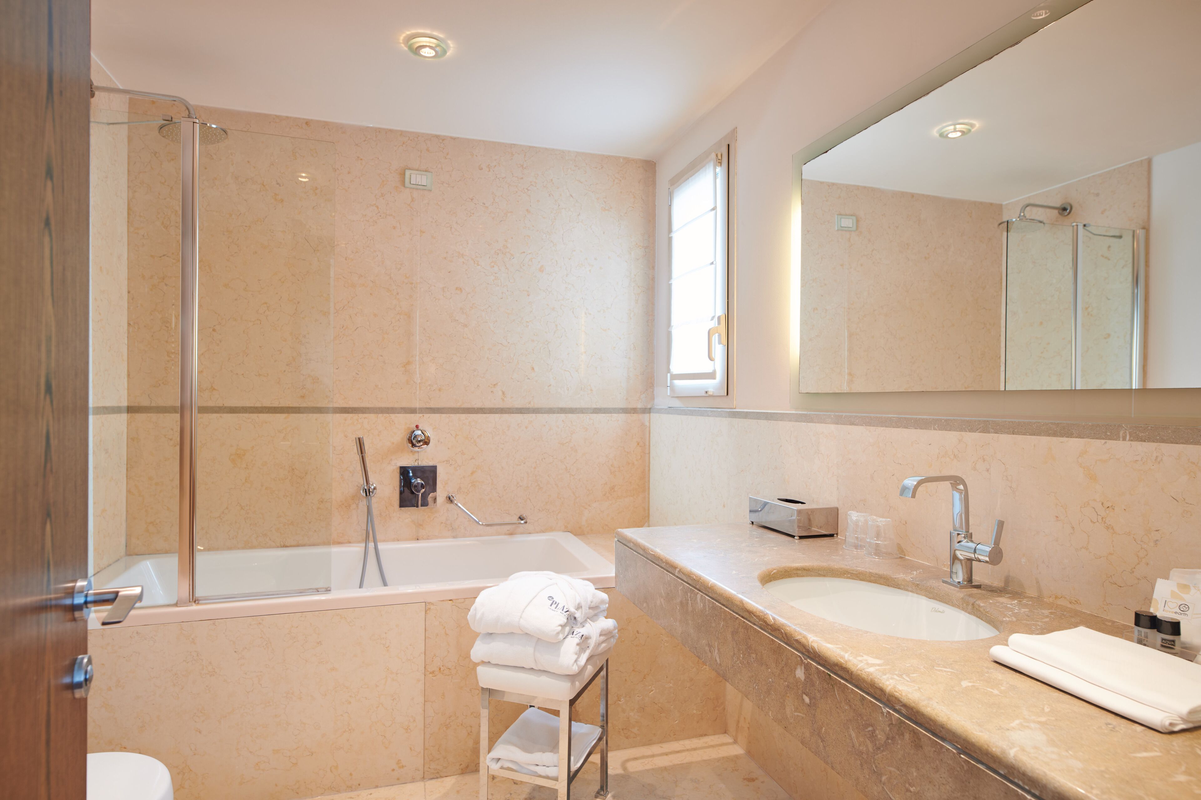 Een moderne badkamer met een bad, een wastafel en een douchecabine van glas.