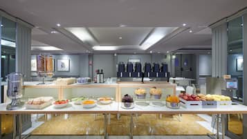 A buffet setup with various food items and a coffee machine.