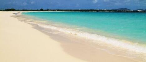 Una playa con agua turquesa cristalina y arena blanca.