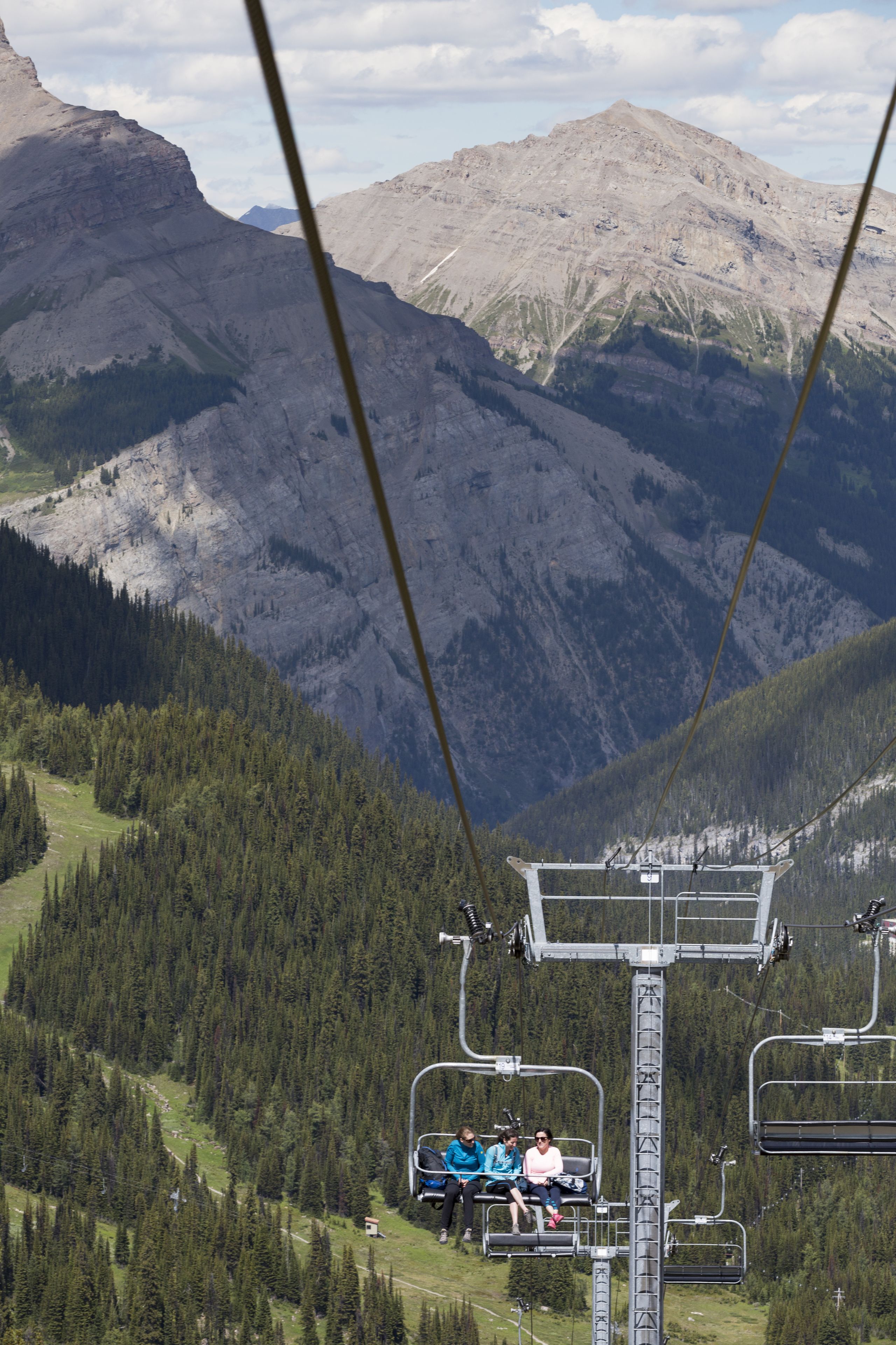 A mountain view with a ski lift and passengers.