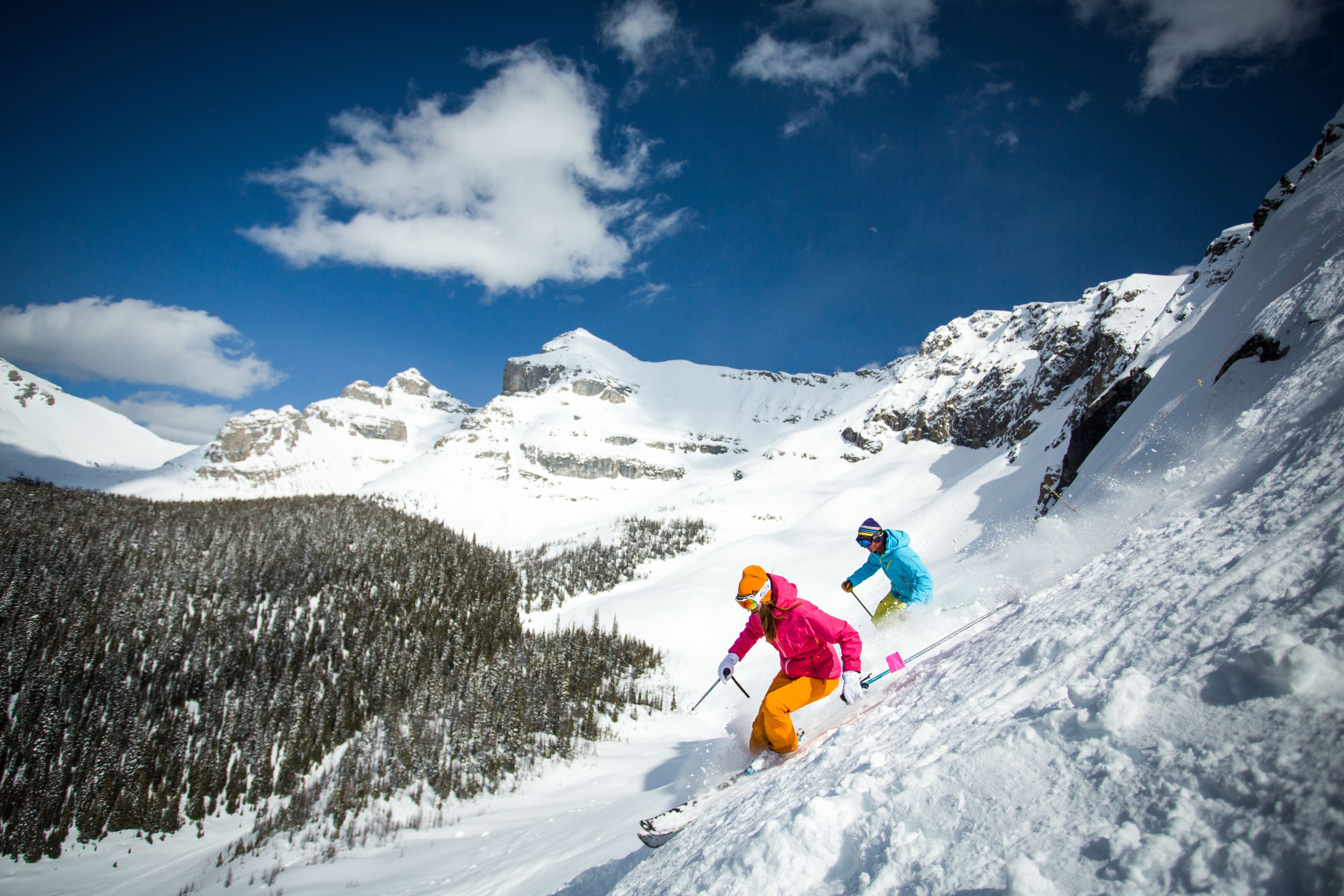 A snowy mountain landscape with skiers.