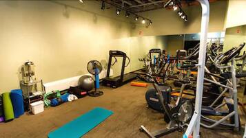 Un gimnasio con equipo de ejercicio, una bicicleta estática y una colchoneta de yoga.
