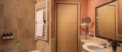 A bathroom with a bathtub, a sink, a mirror, and a door.