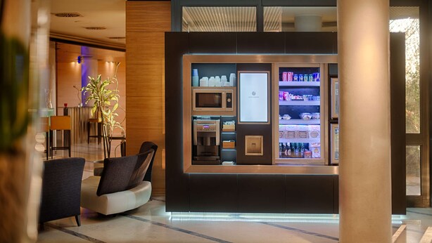Um hall de hotel moderno com área de estar, um minibar e vista para o exterior.