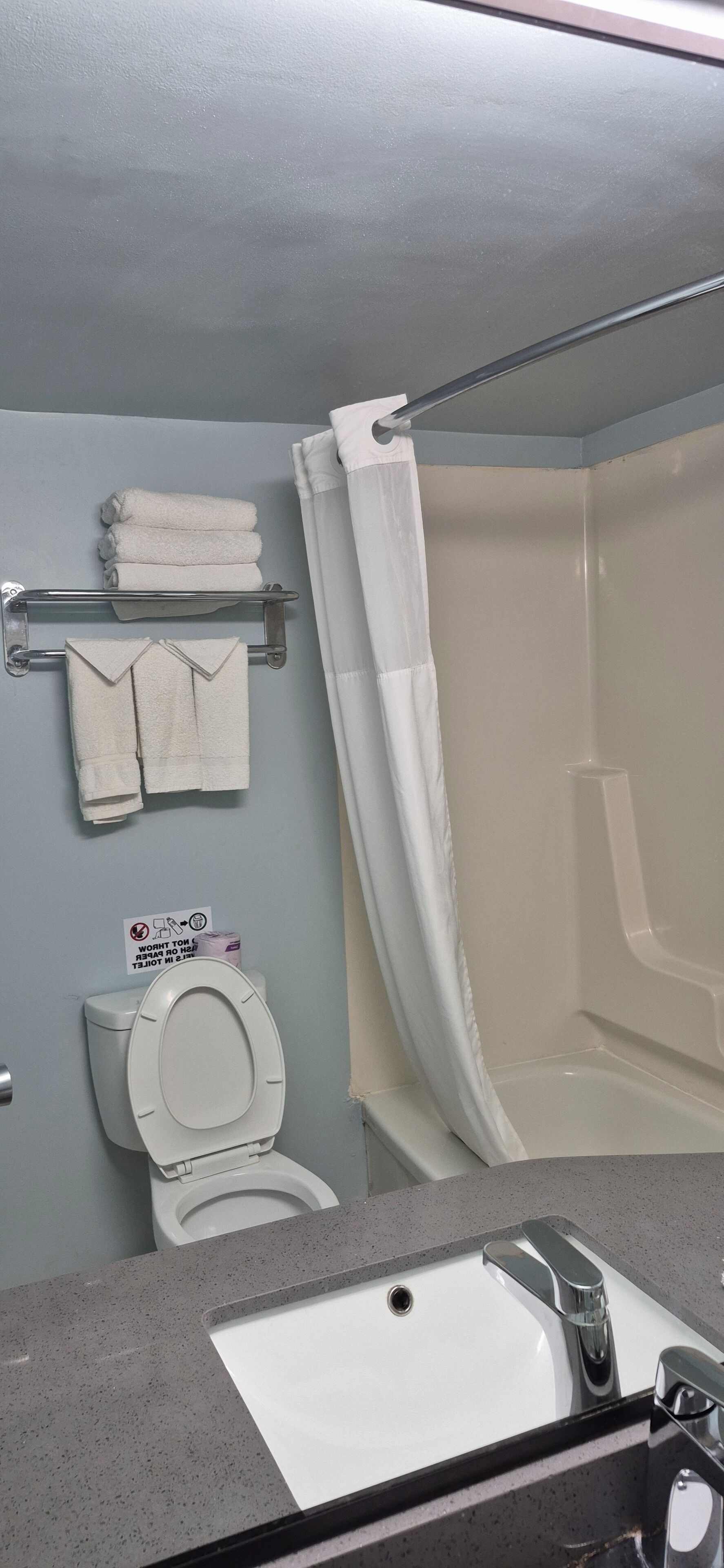 Egy fürdőszoba, amelyben WC, mosdókagyló és zuhanyzó található.