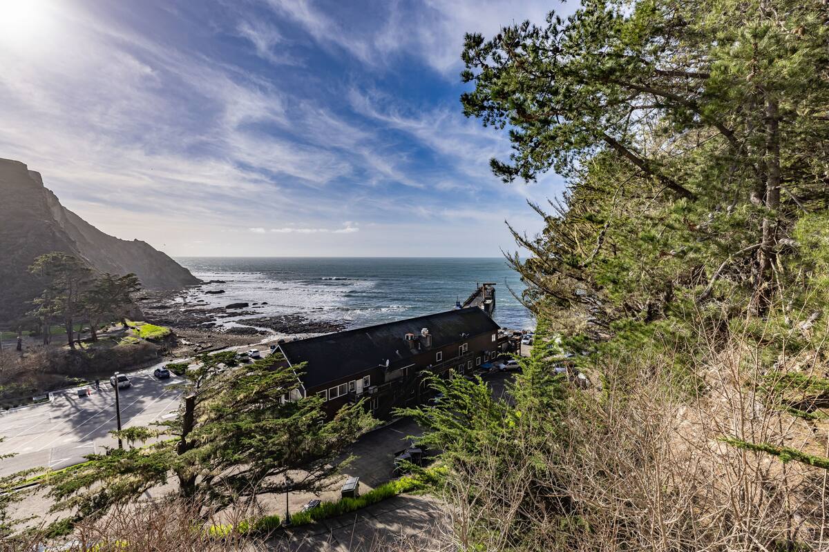 A coastal building with a view of the ocean and cliffs.