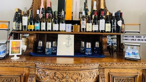 Un espace bar avec un assortiment de bouteilles de vin et un panneau indiquant les options proposées pour le petit-déjeuner chaud.