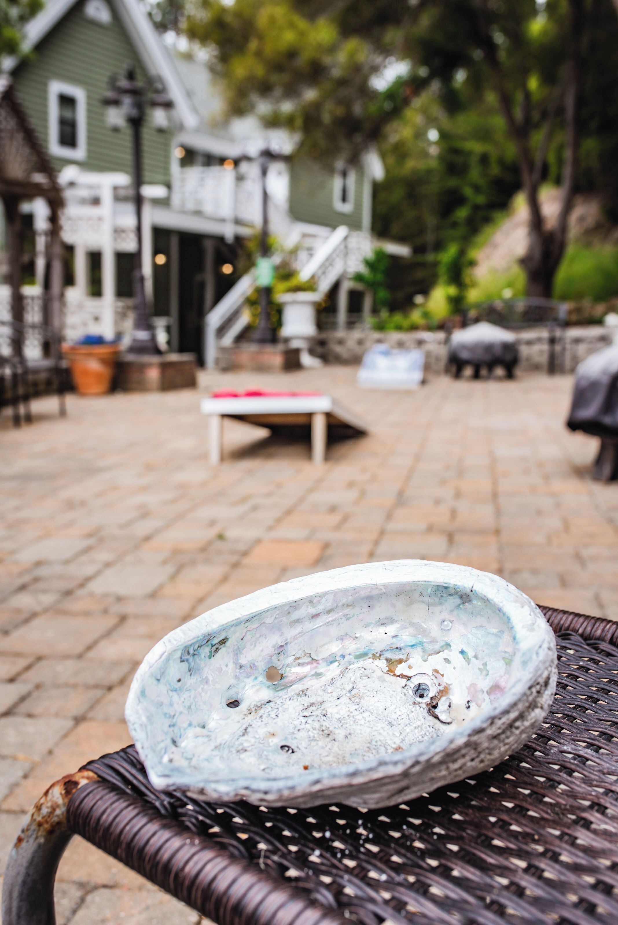 A rustic outdoor seating area with a wicker table and a decorative plate.