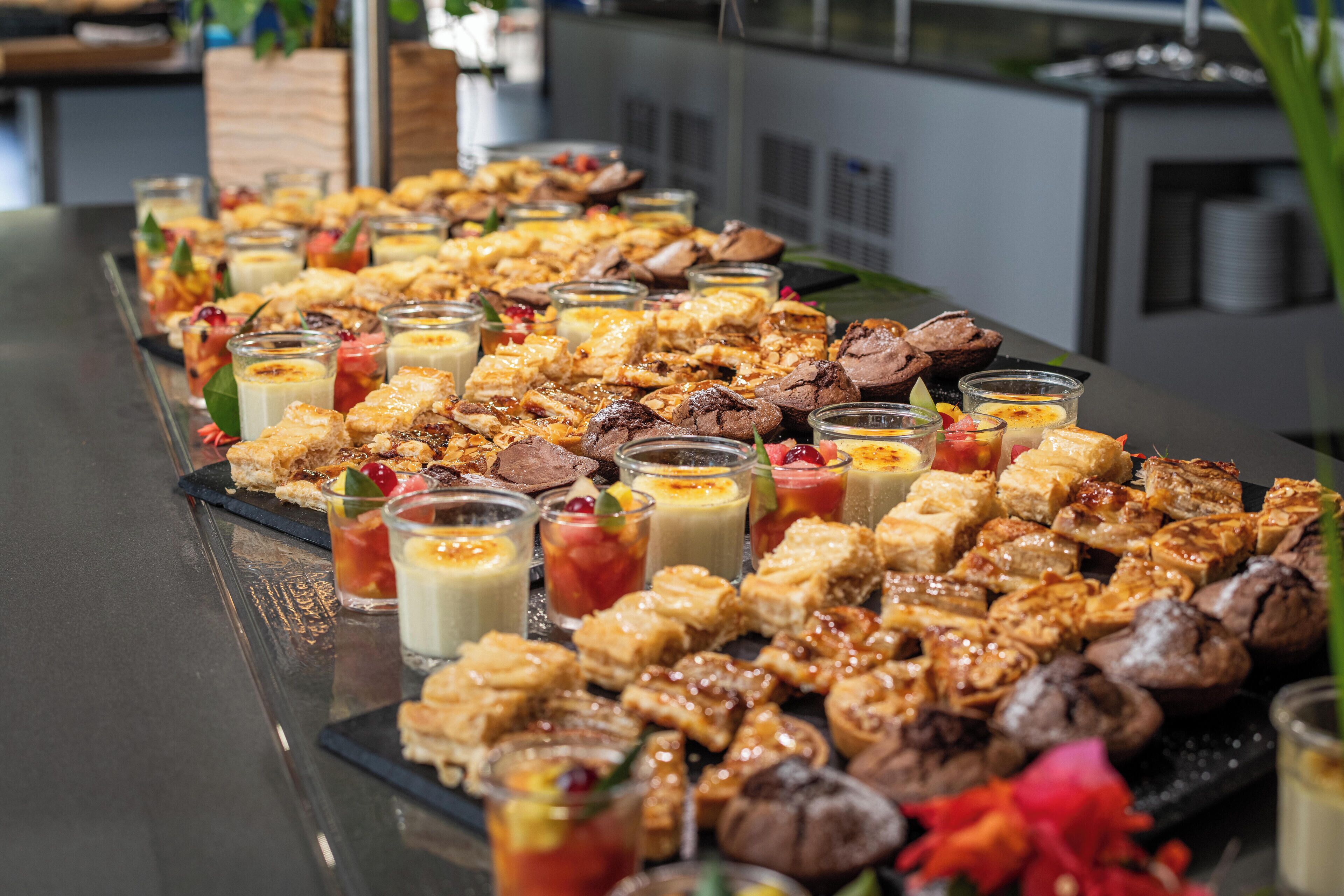 Una mesa de bufé con diversos alimentos y bebidas.