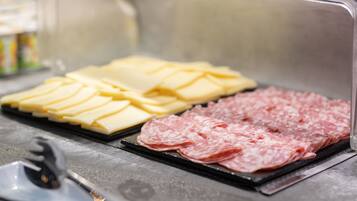 A selection of sliced meats and cheeses on a tray.