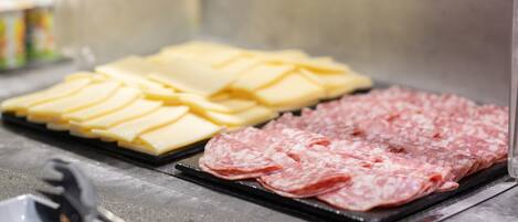 A selection of sliced meats and cheeses on a tray.