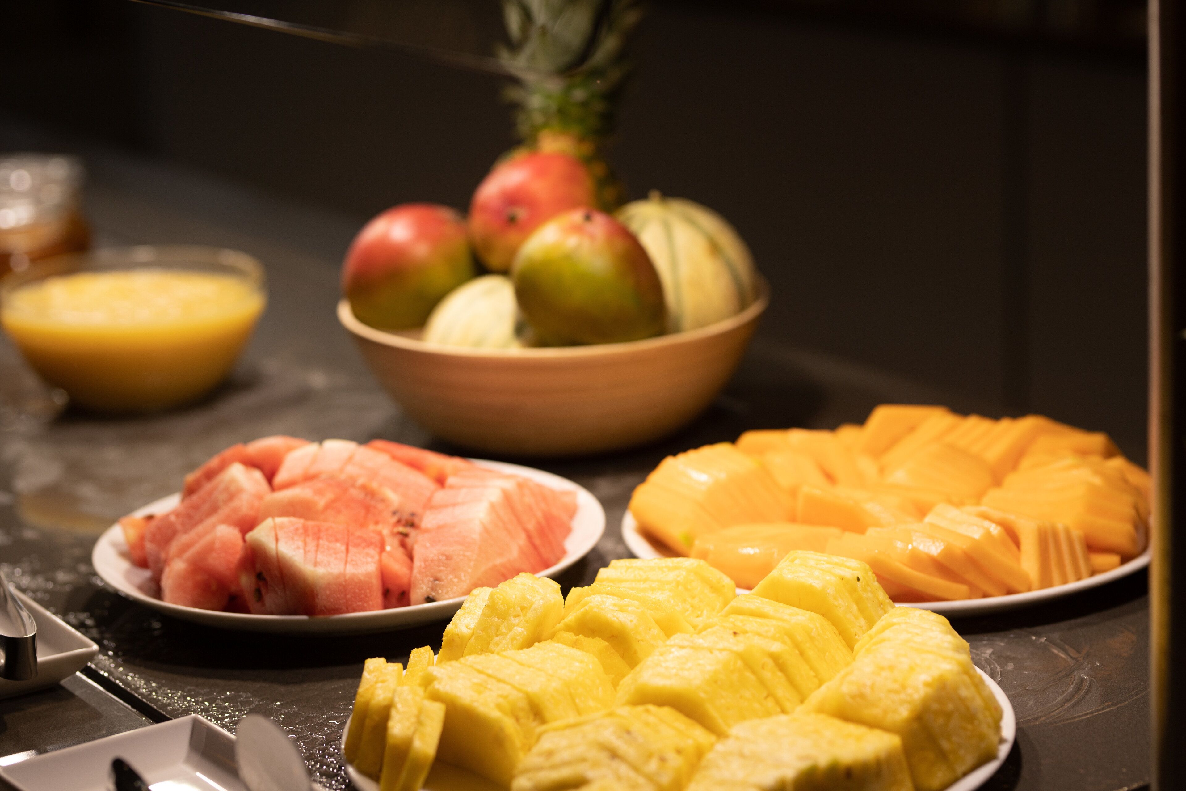 A fruit platter with watermelon, pineapple, and mango slices.
