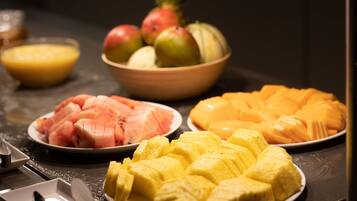 A fruit platter with watermelon, pineapple, and mango slices.
