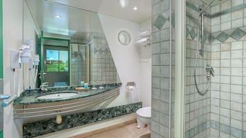 A modern bathroom with a large mirror, a sink, a toilet, and a shower area.