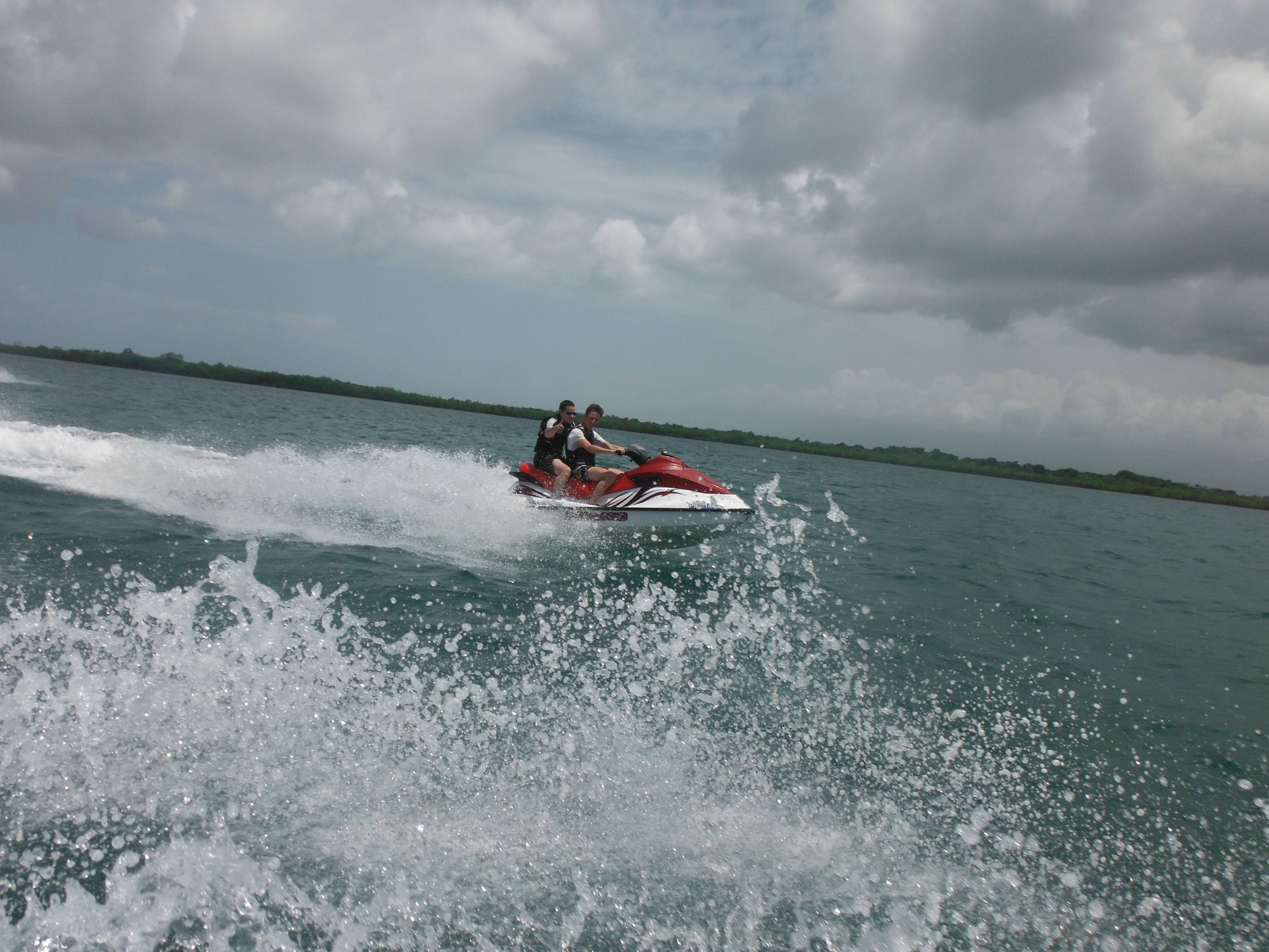 Two people on a jet ski creating a wake.