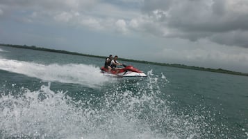 Dos personas en un jet ski generando una estela.