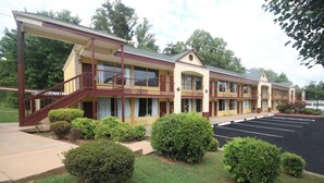 A motel with a two-story structure, a covered walkway, and a parking lot. - Americas Best Value Inn Pilot Mountain (Pilot Mountain)